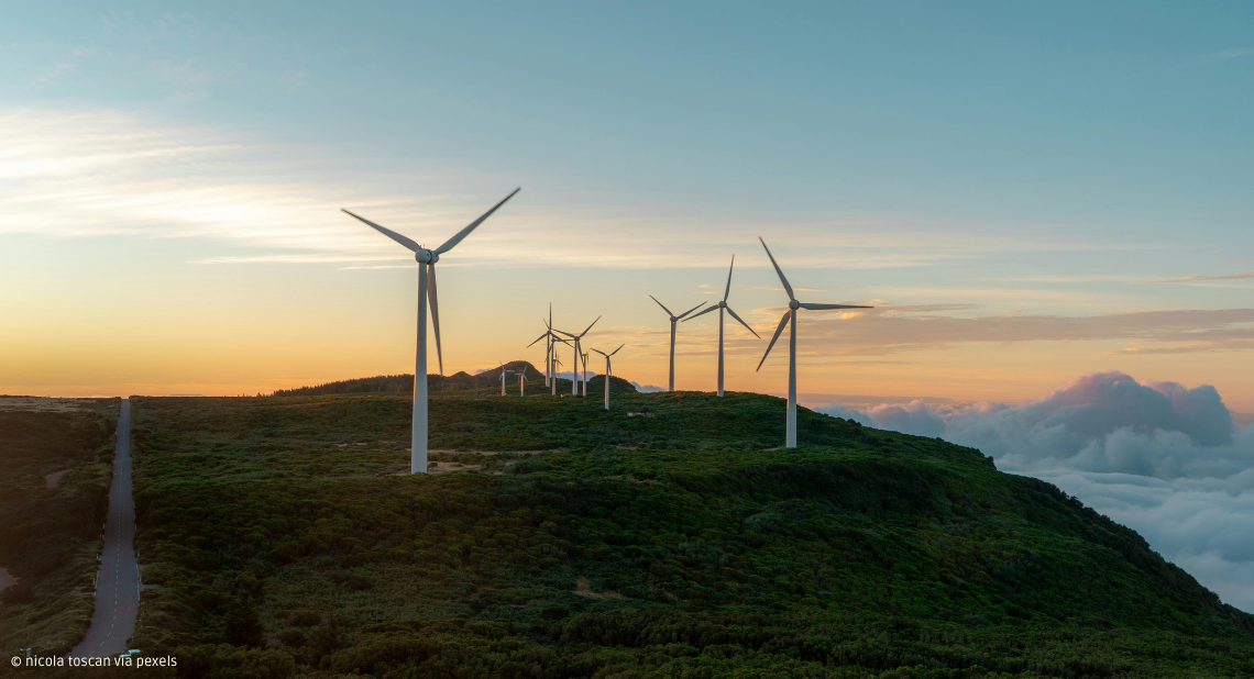 Windräder auf Bergen vor Wolken