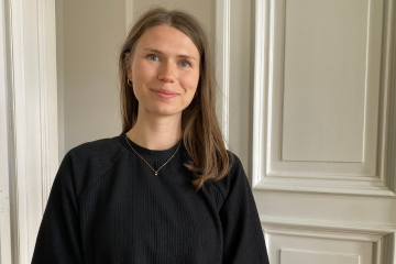 Porträt von Hannah Siegesmund vor einer weißen Tür