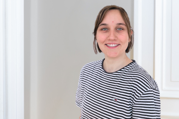 Porträt von Alina Jung in einem gestreiften T-Shirt vor einem weiß-grauen Hintergrund