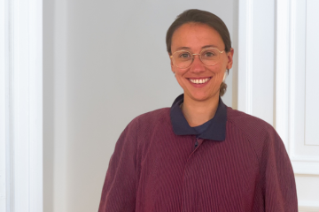 Porträt von Tabea Fröber vor einer weißen Altbau-Tür