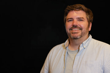 Porträt von Matthias Hoffman vor einem schwarzen Hintergrund