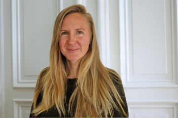 Porträtfoto von Franziska Liepe vor einer weißen Altbau-Tür