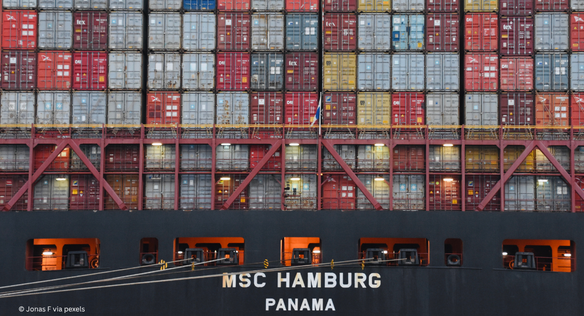 Containerschiff von hinten aufgenommen mit Containern auf Deck