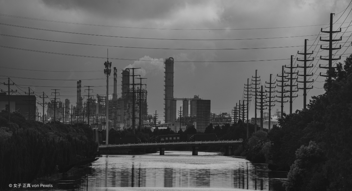 Flucht auf Fabrik mit Fluss und Strommasten in Schwarz-Weiß