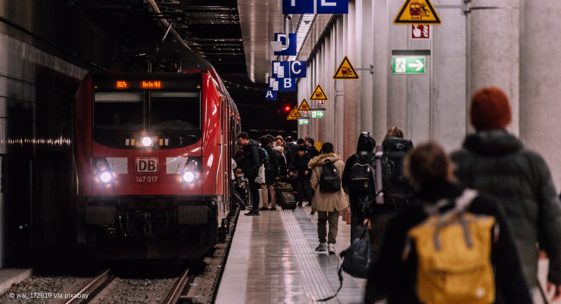 Zug am Bahnsteig mit Fahrgästen