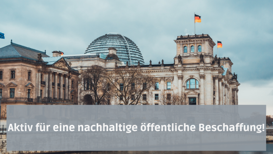 Der Schriftzug "Aktiv für eine nachhaltige öffentliche Beschaffung!" vor dem Reichstaggebäude, welches heute als Deutscher Bundestag fungiert. Das Gebäude ist mit Deutschland-, sowie mit einer EU-Flagge bestückt