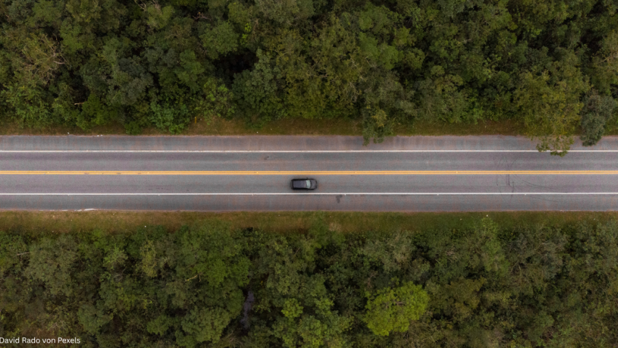 Auto auf einer Waldstraße per Drohne aufgenommen