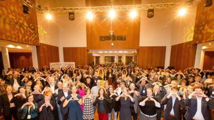 Besucher:innen des BNW-Jubiläums halten Herzen in die Höhe