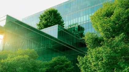 Ein Glasgebäude mit Bäumen im Vordergrund
