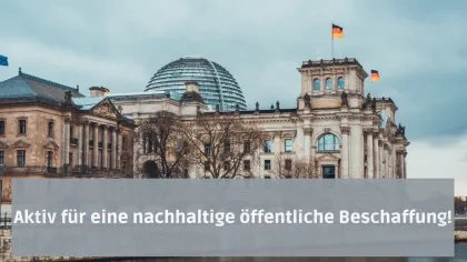 Der Schriftzug "Aktiv für eine nachhaltige öffentliche Beschaffung!" vor dem Reichstaggebäude, welches heute als Deutscher Bundestag fungiert. Das Gebäude ist mit Deutschland-, sowie mit einer EU-Flagge bestückt