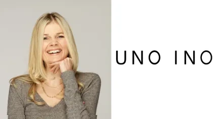 Porträt von Anita Merzbacher. Sie hat lange blonde Haare und die Hand am Kinn und lacht. Auf der zweiten Hälfte des Bildes ist das Logo von Uno Ino auf weißem Hintergrund