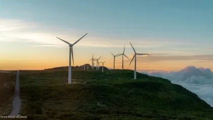 Windräder auf Bergen vor Wolken
