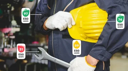 Ein Mensch in Blaumann mit einem gelben Helm unter dem Arm und einem großen Schraubschlüssel in der Hand. An Kleidung und Werkzeugen wird der ESG-Score angezeigt