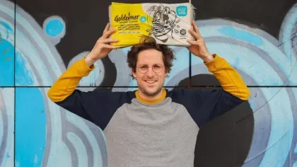 Malte Schremmer, Gründer von Goldeimer, mit Goldeimer Klopapier in den Händen
