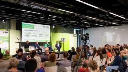 Vier Diskutierende auf der Bühne bei der BNW-Jahrestagung 2026 „Wie Geld wirkt“, das Publikum hört zu