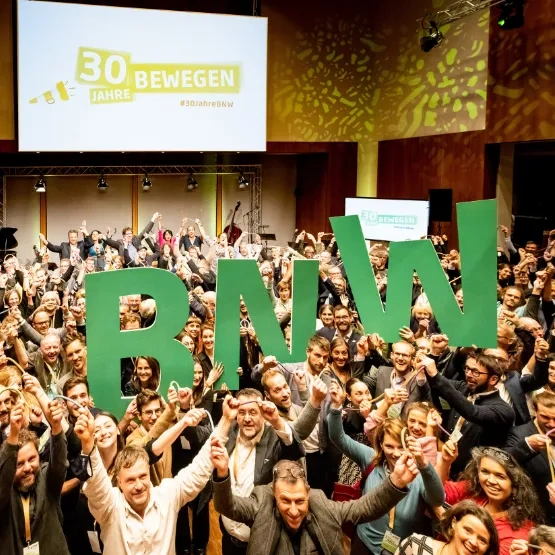 Besucherinnen des BNW-Jubiläums Halten die Buchstaben BNW in die Luft